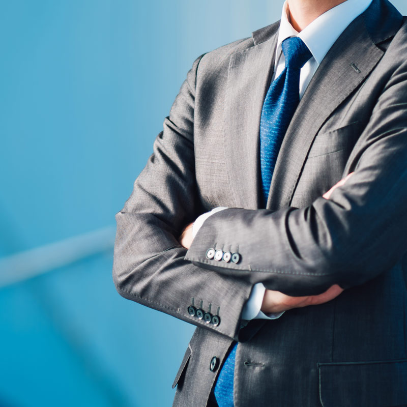 man in suit folding arms